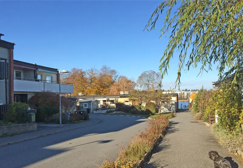 Glimt av vattnet och bryggorna sedd mellan två av husen.